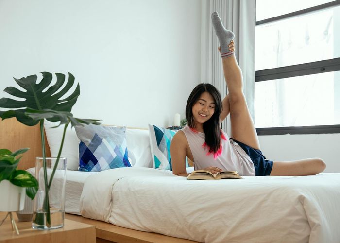 Person stretching peacefully by a window with morning light.